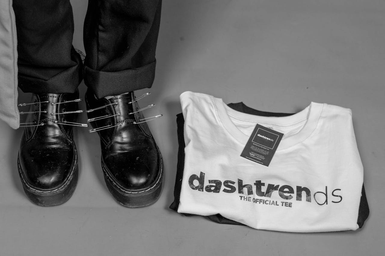 Home Stylish black shoes paired with a trendy white t-shirt on a gray background.